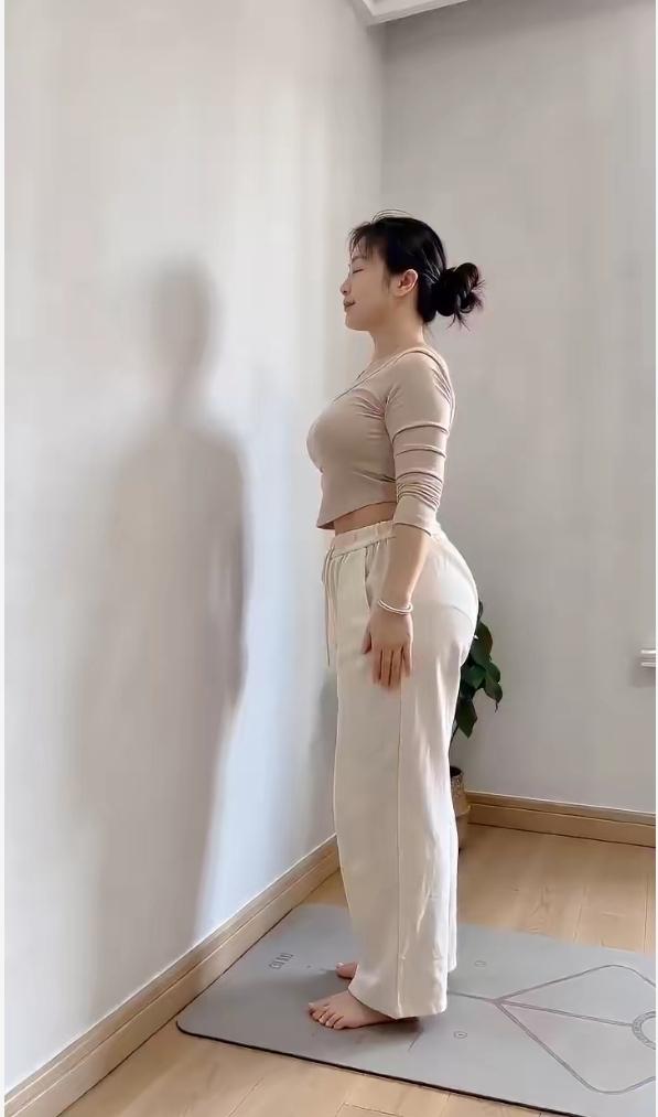 漂亮姐姐在家练体形，站得很直。