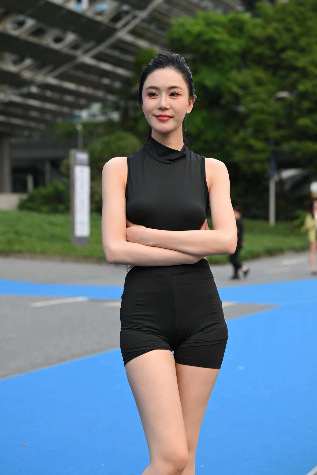 黑色无袖套装的版型放大了身形优势：腰的窄度、臀腿的轮廓感被清晰呈现，肩背线条的纤