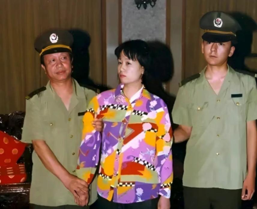 2000年，刘艺霞被押赴刑场。照片里的她，穿着花衬衫，被两名警察押送着，表情死寂