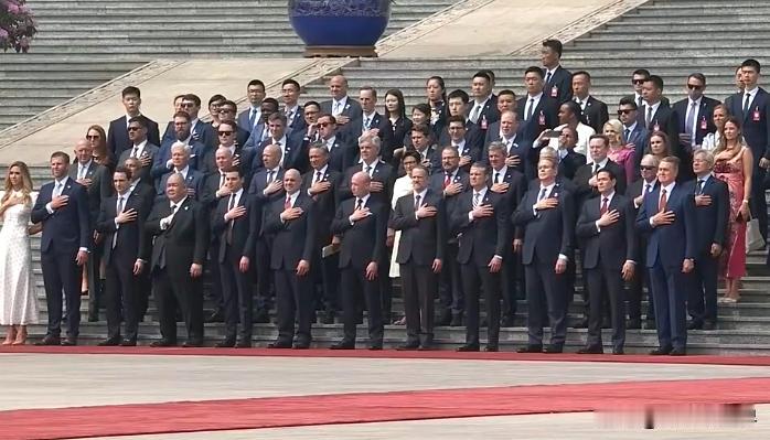 欢迎仪式上，奏起美国国歌那一刻，随行所有官员，全部统一手捂胸口，行平民礼仪。