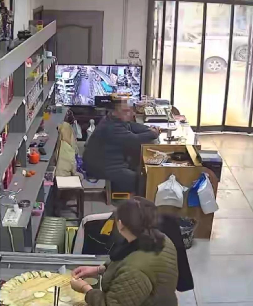 2月26日，河南新乡辉县市。63岁的男子和妻子守店。他坐在收银台，和在旁边包饺子
