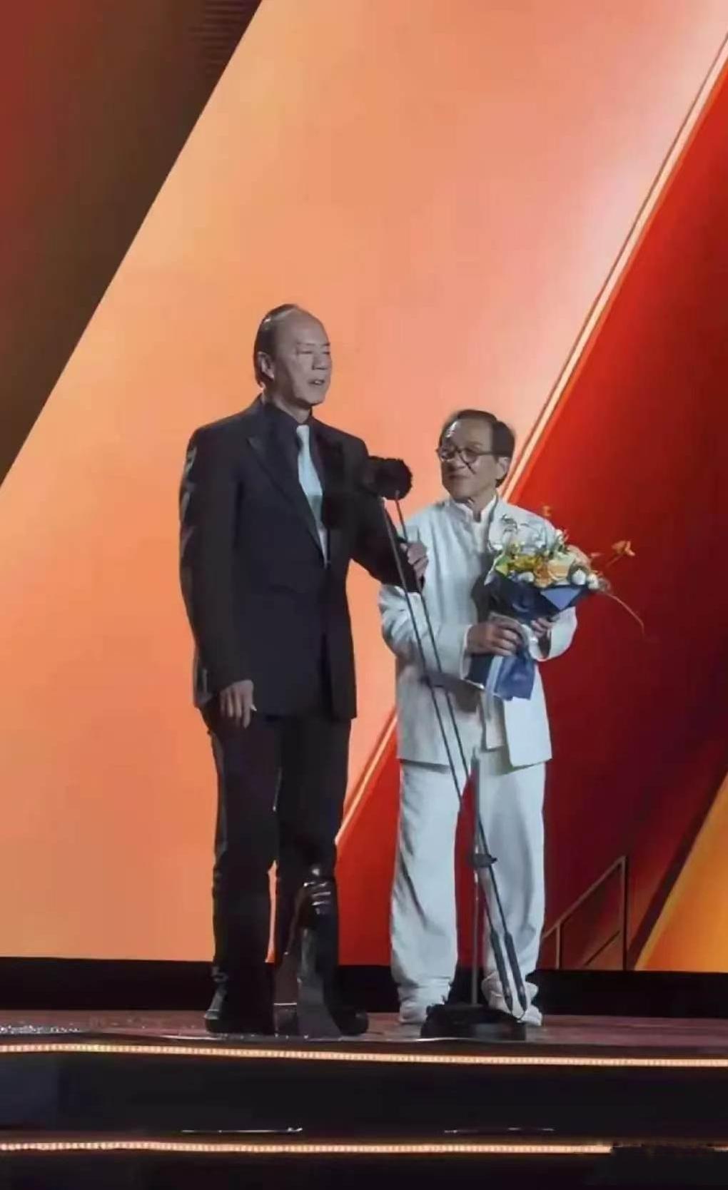 72岁的成龙给80岁的狄龙颁发终身成就奖时，由于狄龙身高比较高，显得成龙看上去比