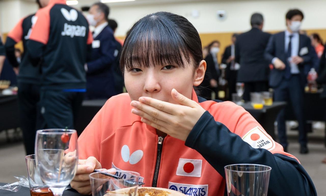 张本美和还是小孩子啊，看到好吃的就停不下来，嘴巴塞得鼓鼓的，还挺可爱的。日本乒协