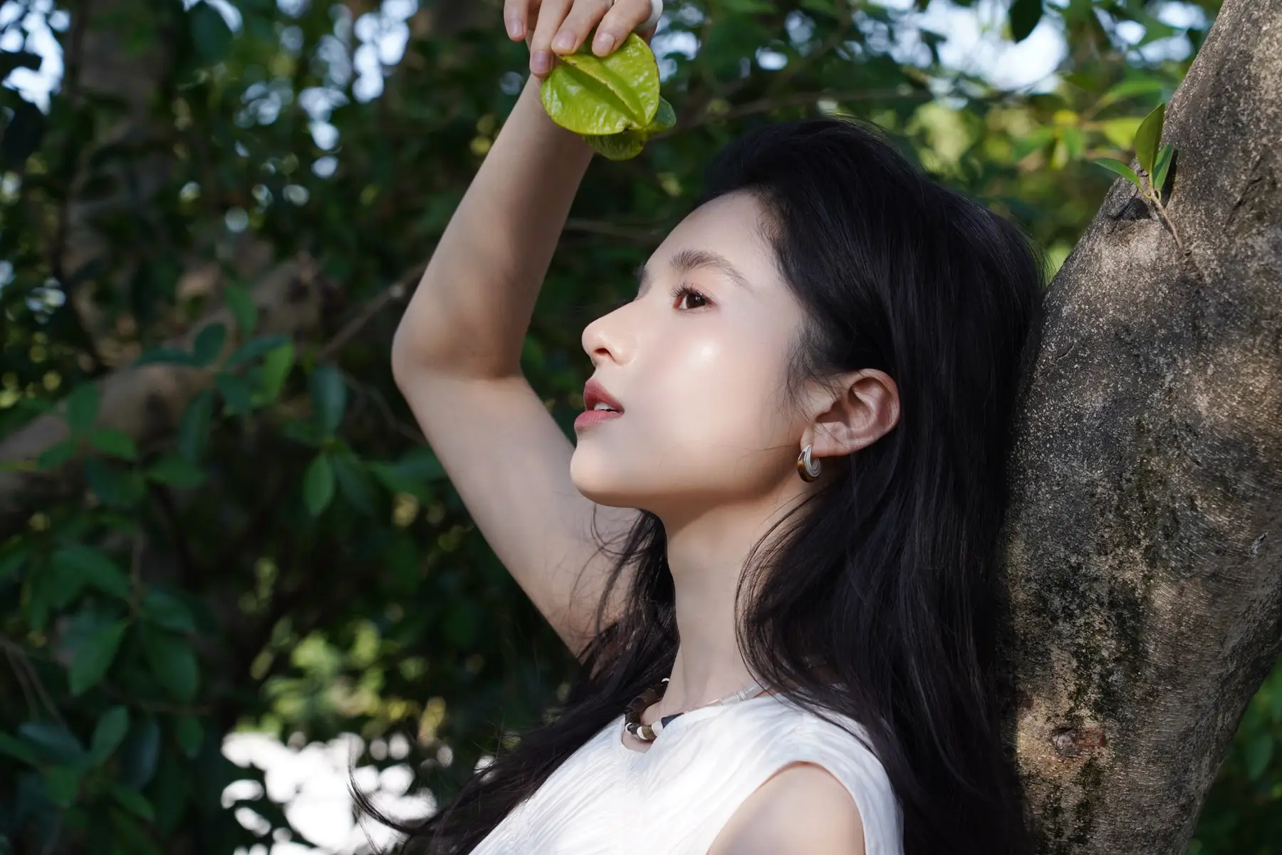 张婧仪穿简约白裙林间漫步，光影斑驳下清新灵动