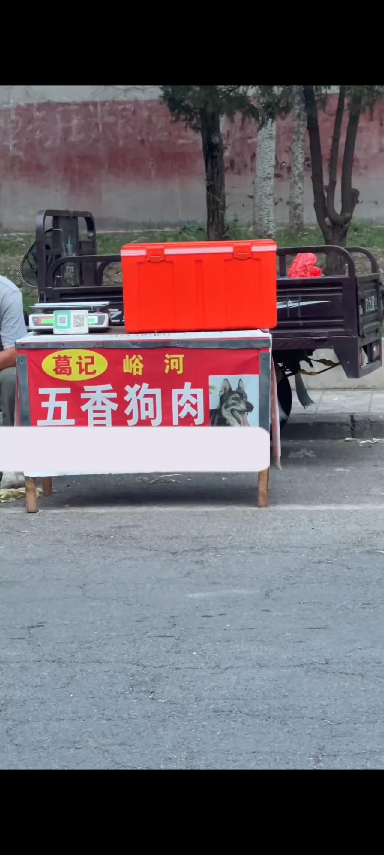 这位大哥竟然毫不掩饰的将抓捕回来的流浪狗，制作成美食以后，又毫不避讳的来到一处集