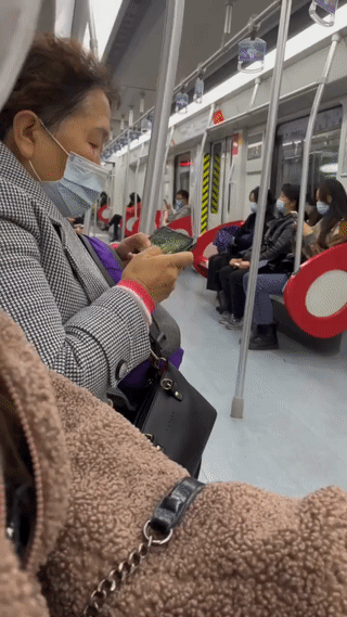 谁说老年人不喜欢玩手机游戏？瞧这位东北大妈，她在地铁上用手机玩“王者荣耀”看起