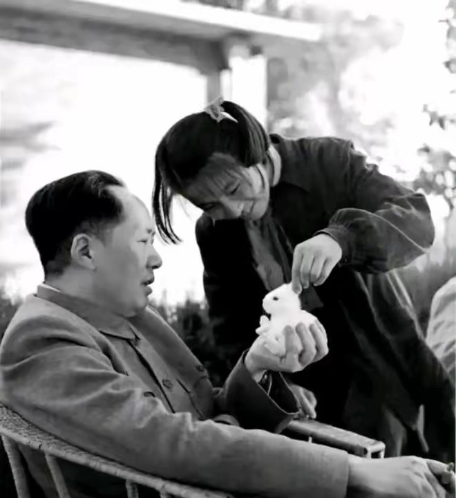 照片拍摄于上世纪50年代初，照片中的主席坐在藤椅上，一脸的慈爱。右手夹烟，左手端