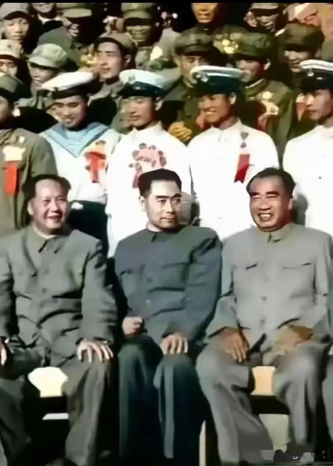 毛主席、周总理、朱总司令与战士们合影留念，三位伟人神情舒展，眉眼含笑，笑容温柔慈