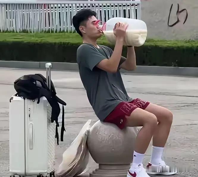 一新疆大学生脖子上挂个脸大的馕饼，手里提着一大桶牛奶去山东上学，照片在网上传开了