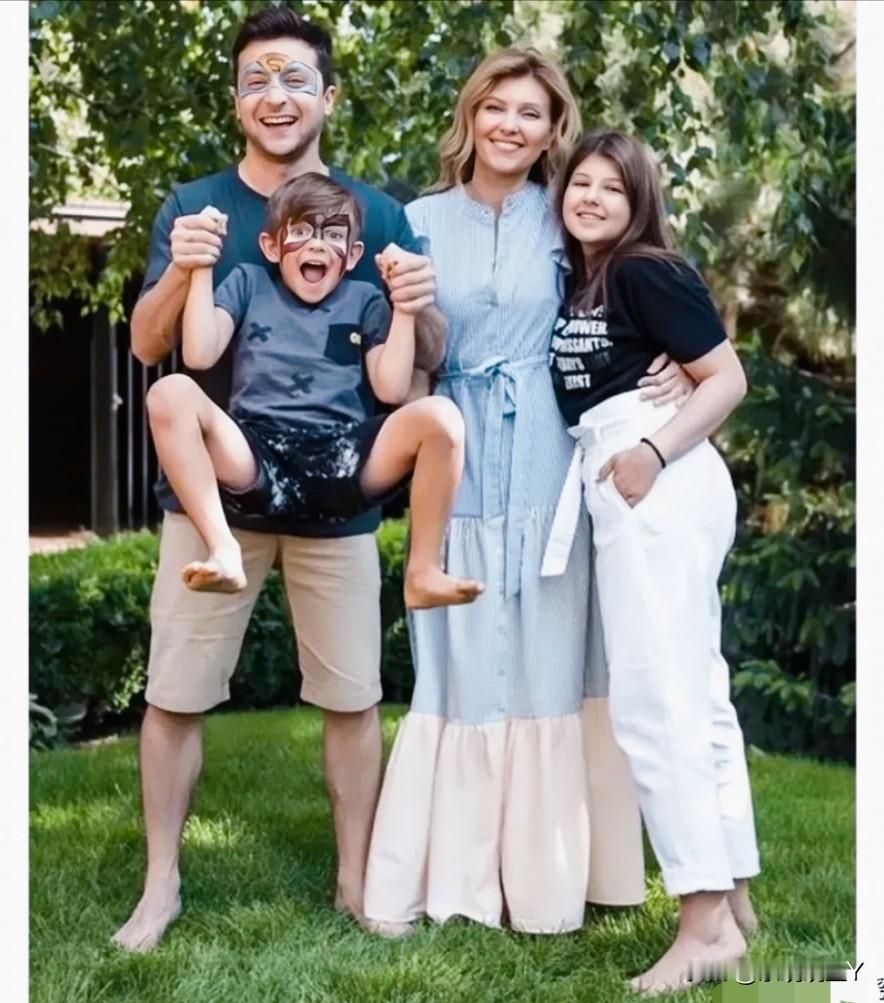 这是泽连斯基与他的妻子及儿女在户外草坪上的一张全家福，拍摄于俄乌战争前。一家四口