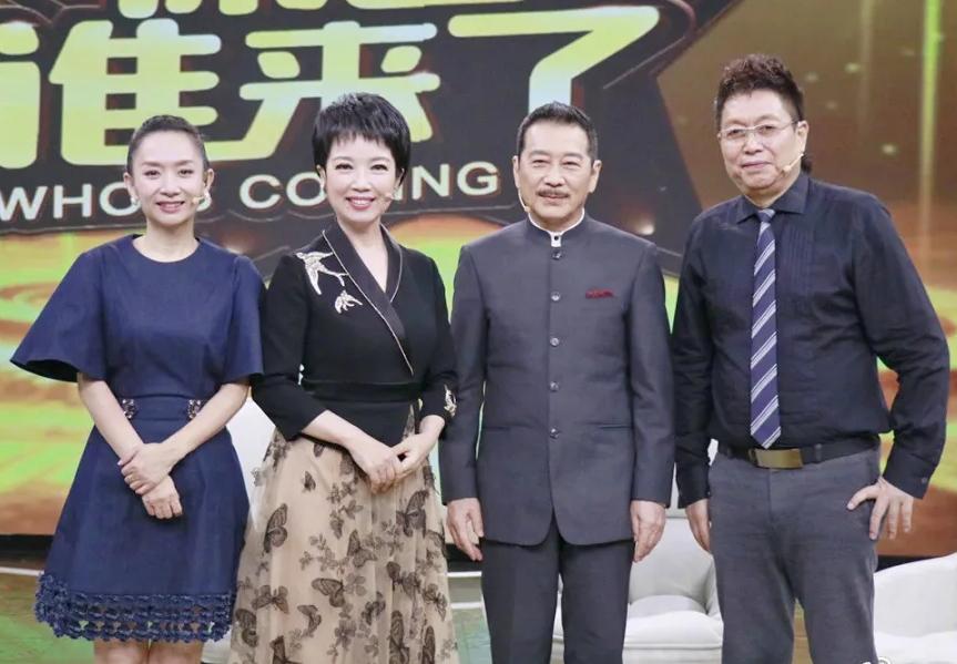 镜头中的王为念老师高大修伟，双目如潭，发型蓬松，造型饱满，风度翩翩；一袭蓝色衣裙