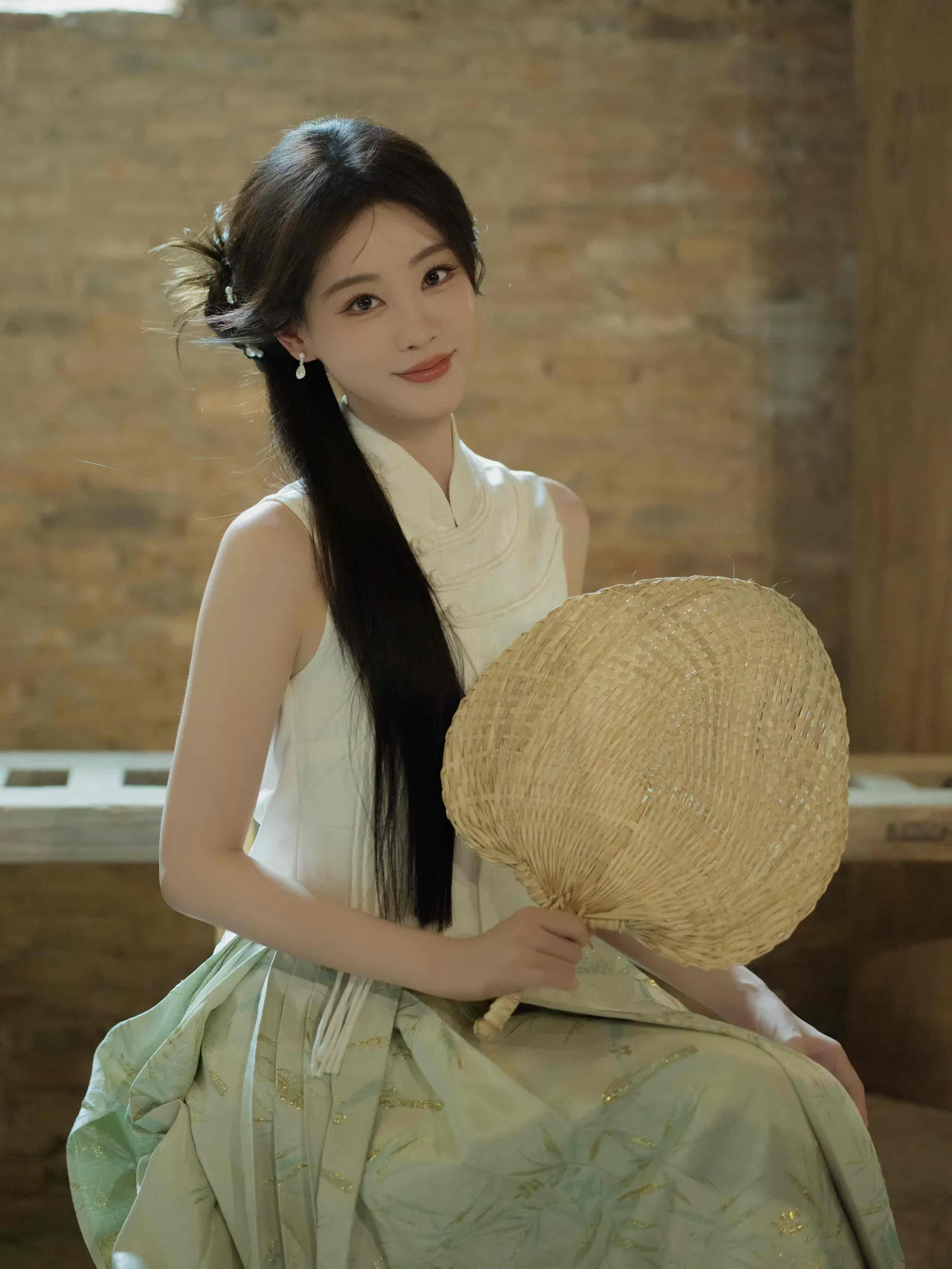 这位姑娘拿着扇子，穿得很优雅。(祝绪丹)