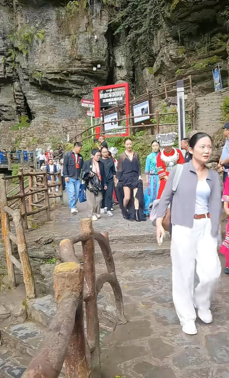 高圆圆现身恩施腾龙洞，当天穿了一件长款黑色拖地连衣裙，短筒高跟鞋。这身俗气的着装