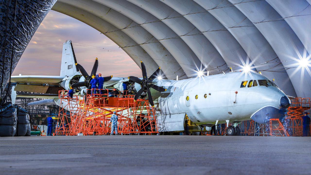 海航的运八反潜巡逻机在自己的大棚里进行现场维护，发动机的整流罩已经打开，工作台架