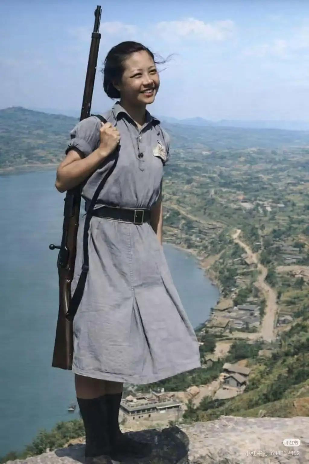 1941年，重庆，在抗日战争中持枪而立的女战士。她站在山巅，江风拂过发梢，灰布裙