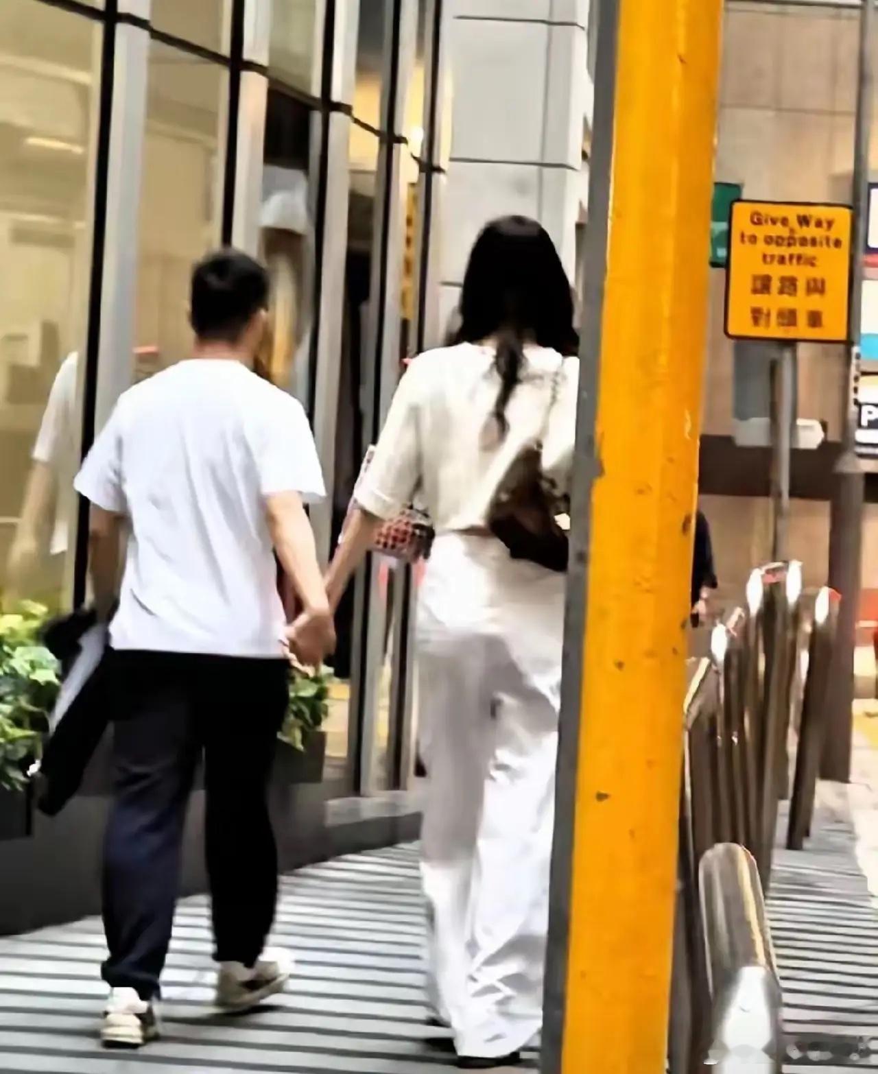 哪怕穿平底鞋，背影都比何猷君高出一截。但你看他俩牵手那个劲儿，完全没...