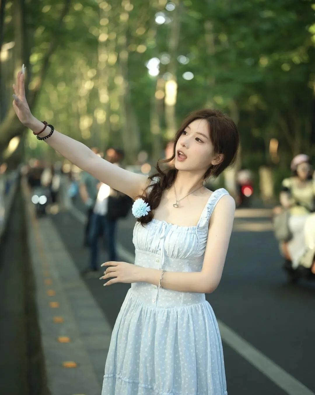 傍晚的风裹着树影的光斑，浅蓝色裙摆晃成夏天最软的云。抬手碰了碰漏下来的阳光，连空
