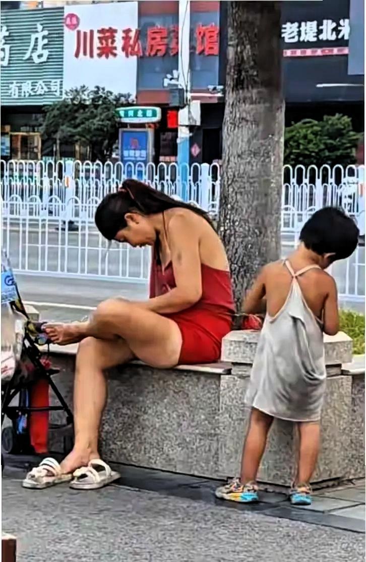 徐州街头出现一对特殊的流浪母女，母亲穿红色连衣裙打扮时尚，路人拍下视频后，大家纷