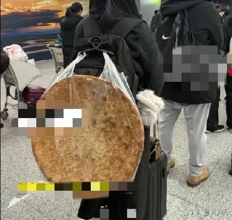 12月29日，新疆乌鲁木齐，一女子到新疆乌鲁木齐旅游，背回一张7元钱的馕，在机场