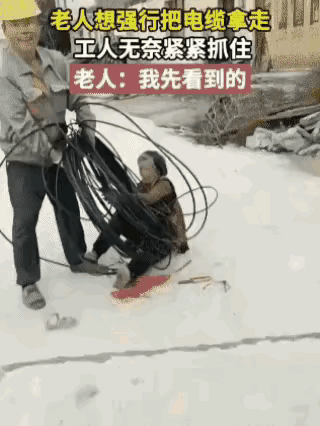 工人师傅正在路边抢修电力设施，一位路过的老太太看见地上放着一卷电缆，就打算直接抱