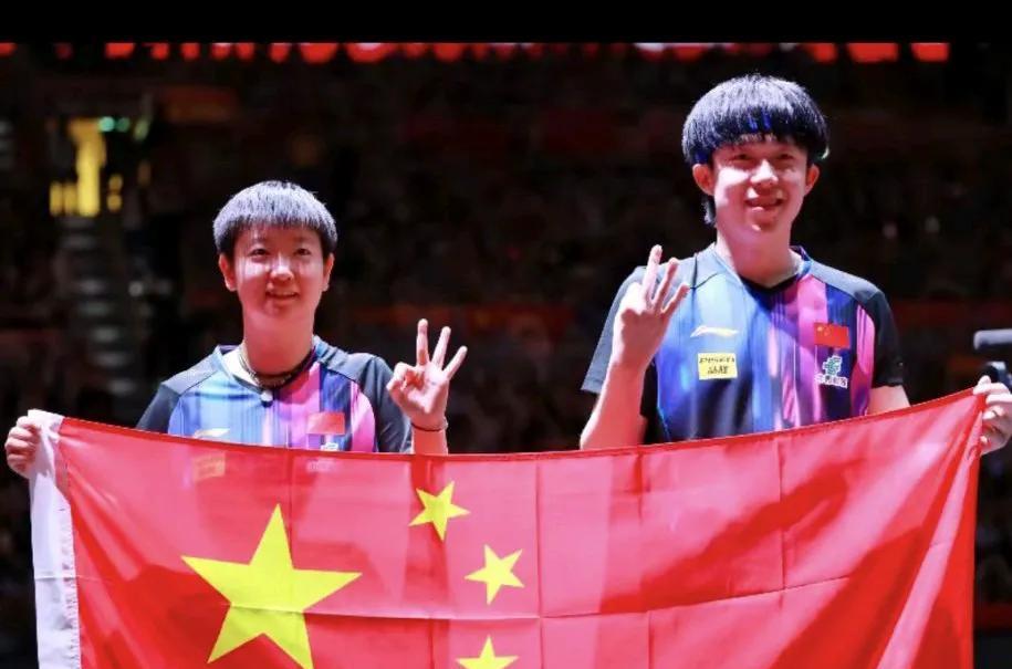 孙颖莎和王楚钦赢得混双比赛第一名。他们一手执国旗，一手比手势。且两人比起了同一个