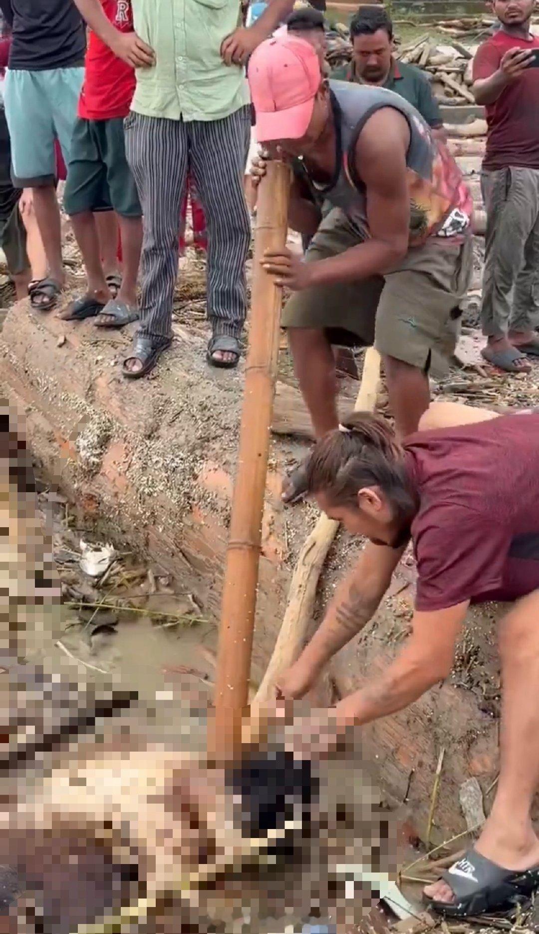洪峰下游，居然有人从尸体上扒拉首饰。我起初还以为他们是在打捞尸体。令人反胃。​