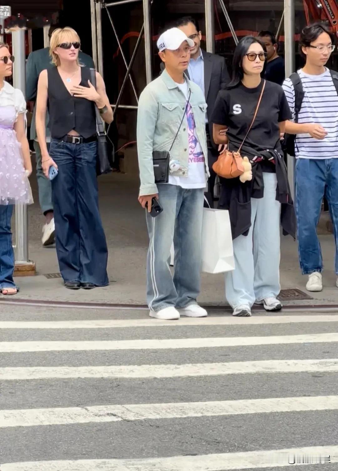 李克勤夫妻俩现身美国，送孩子去上书。李克勤牛仔衣运动裤，带着鸭舌帽，身材不胖不瘦