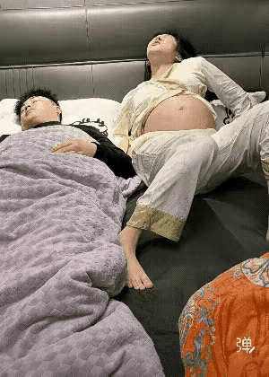 夫妻二人在床上，老公进入了深度睡眠，睡的特别香，老婆怀孕挺个大肚子感觉不舒服在床
