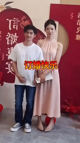 虽然男孩看起来身高有点矮，但是和他订婚的女孩却并不嫌弃他。男孩长得很帅气，女孩