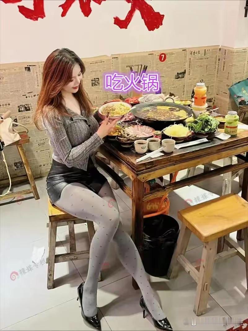 火锅店里面，一桌丰盛的火锅摆满桌面，打扮精致亮眼的女子独自坐在桌前。一身时髦穿