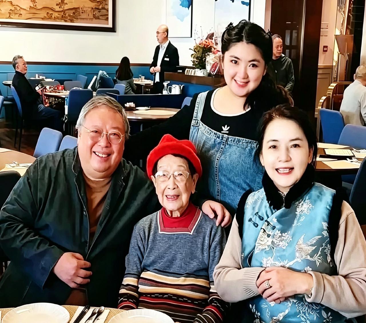 胡慧中一家四口同框。101岁婆婆戴红帽坐中间，笑得特慈祥。一家人整整齐齐，比啥都