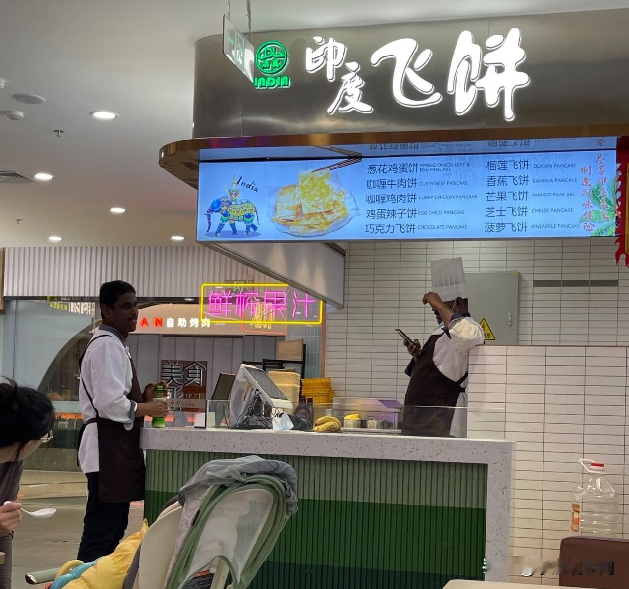这两个印度人在北京一家商场开了一个小吃店，最近生意很不好！这个店在美食街入口，