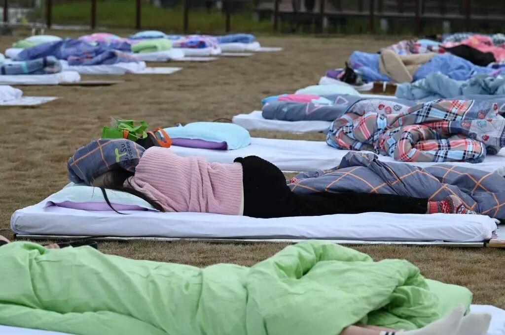 上海举行睡眠大赛现场曝光！现场很多人躺平在草坪上，大赛为选手设置了万元以上的奖