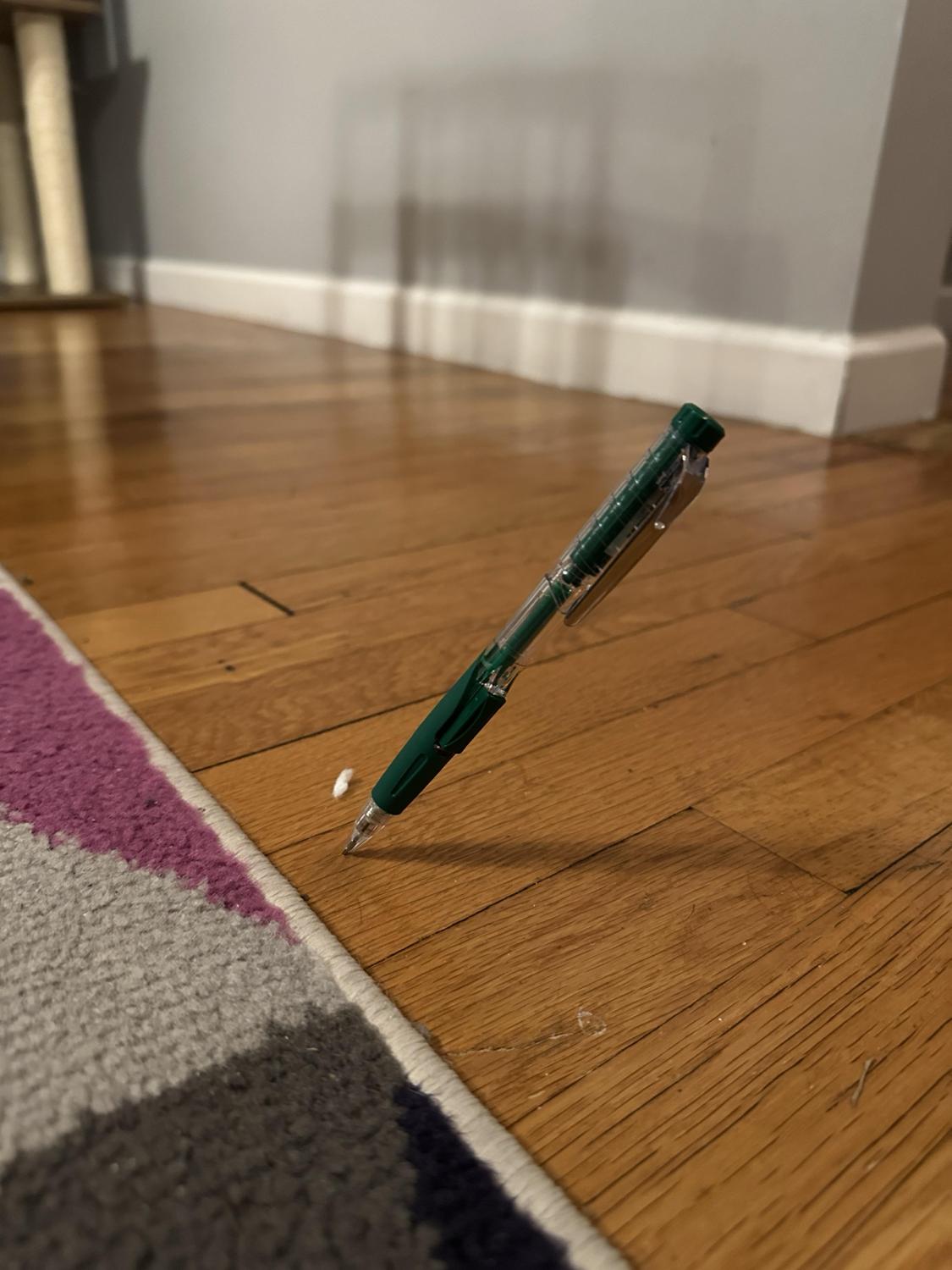 一支自动铅笔掉到地上之后，居然就这么斜斜地插进了木地板里，整个画面看起来像是物理