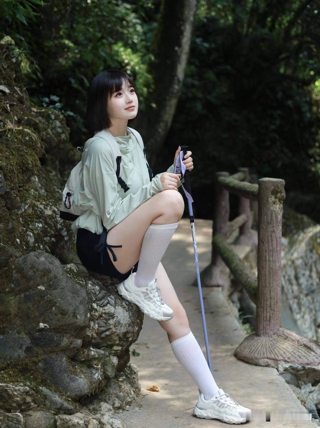 女生在山间小路上休息，风景不错。