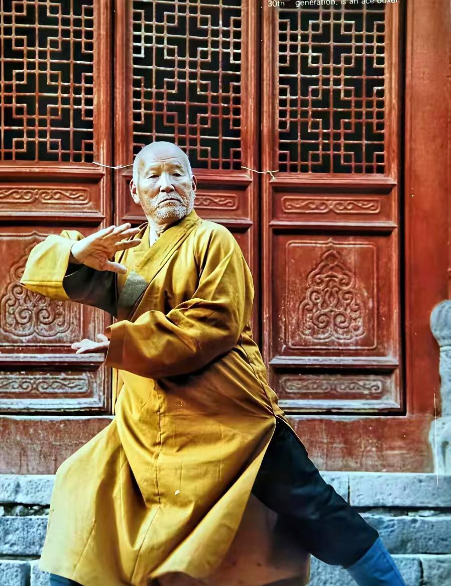 这是一位上了年纪的少林武僧在寺院中练武。这位武僧虽然上了年纪，但他的身板看起很硬