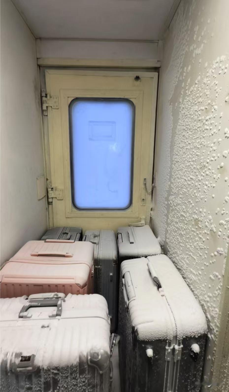 网友分享在漠河火车上。清早在聂河临时停车，到车厢连接处，车厢和行李箱一层霜，冷链