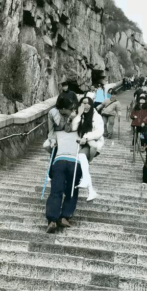 挑山工的身体素质真好，为了多挣点钱，抱着两个美女登山，两个人的体重加在一起至少也