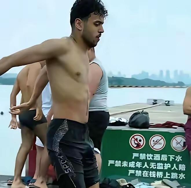 湖北武汉东湖凌波门，一群印度游客无视岸边醒目的“禁止下水”警示牌，直接在众目睽睽