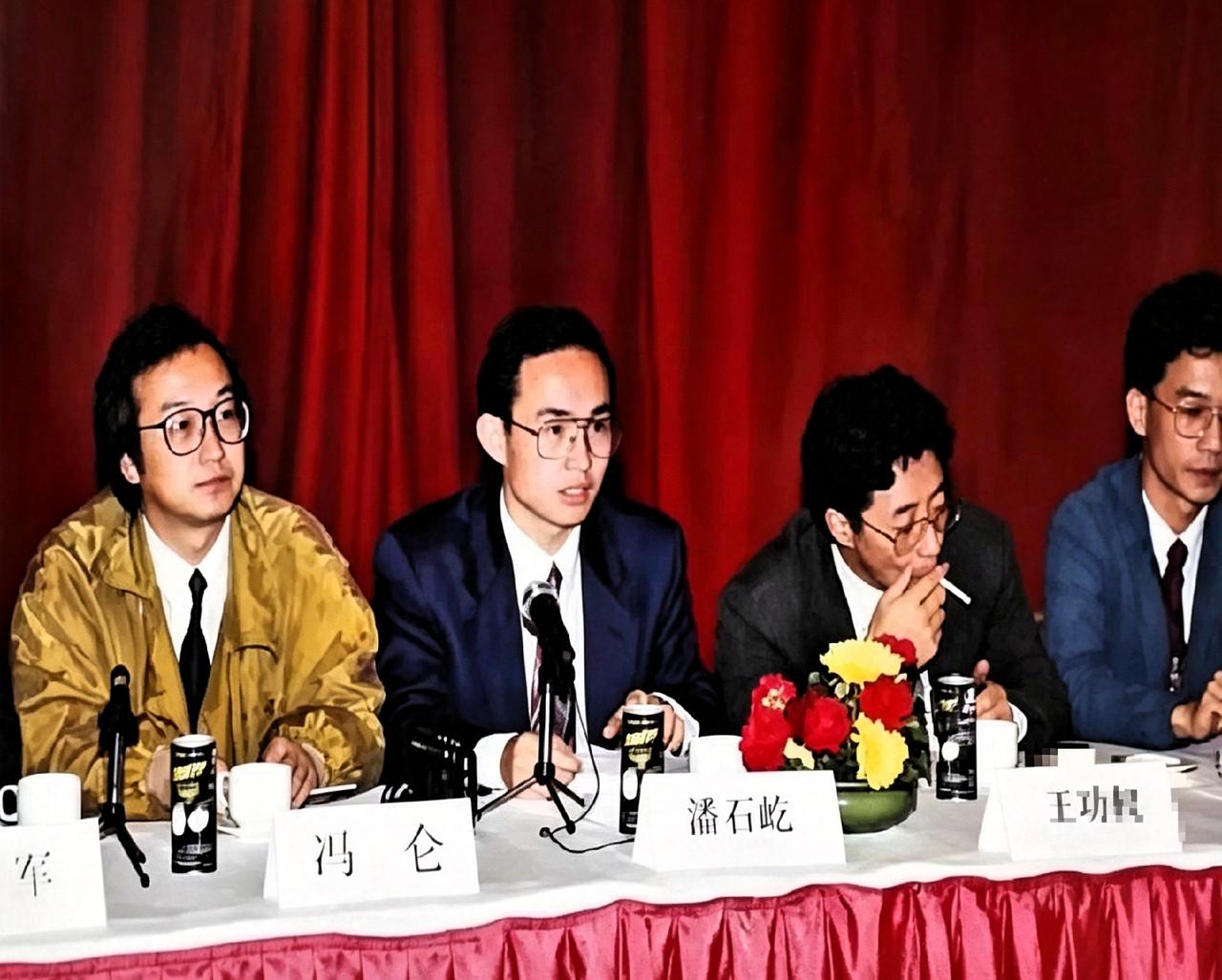 翻到张90年代的老照片。桌上摆着易拉罐，冯仑、潘石屹、王功权坐一排。那会儿大家还
