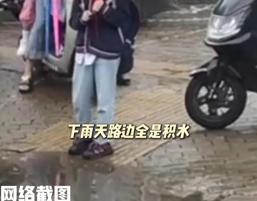 安徽有一小学放学。这日正好天空落雨，路面到处是雨水囤积，走起路来鞋子几乎要湿
