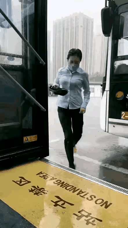 大雨滂沱里；一美女公交司机，为了不误点，拎着鞋子光着脚，淌水进了自己心爱的大公交