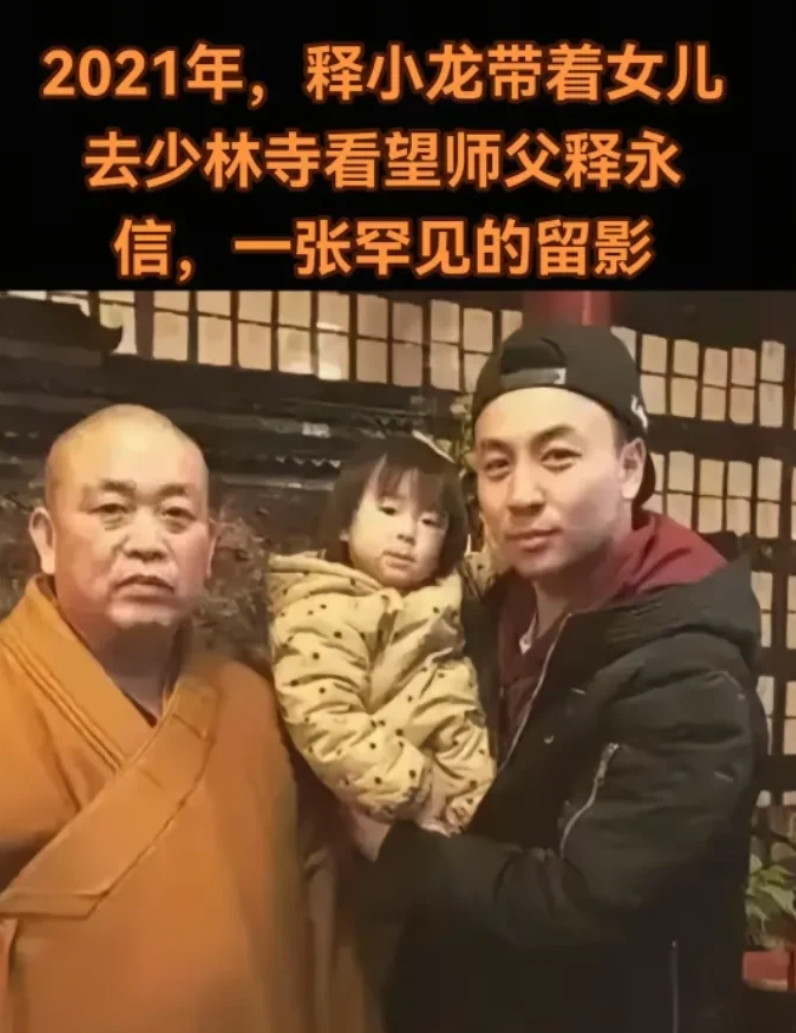 原来释永信是释小龙的师父！这是2021年释小龙怀抱爱女与释永信合拍的一张照片。释