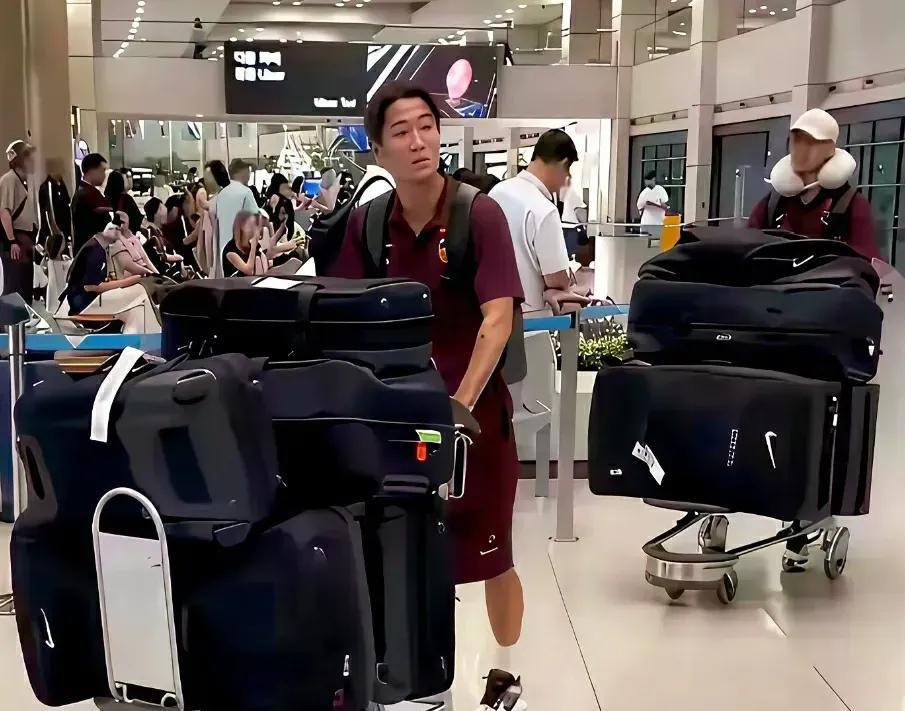 是不是误会国足的行李箱了？我们看到的图片是国足的队员一个人推着好几个行李箱，然