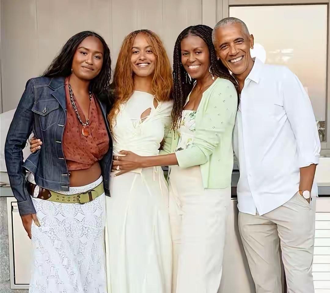 奥巴马头发白了，牙还白得发亮。笑起来还是当年那副模样，一点没变。米歇尔在他身