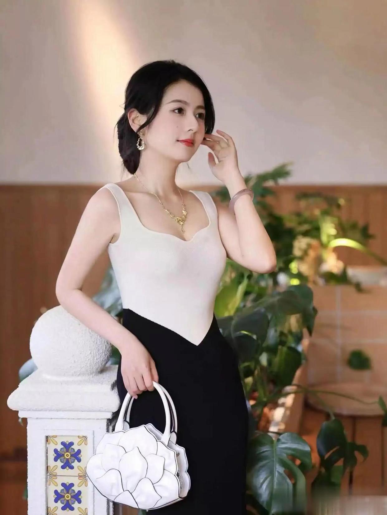 优雅黑裙搭配白色上衣，手提包点缀，气质满分！