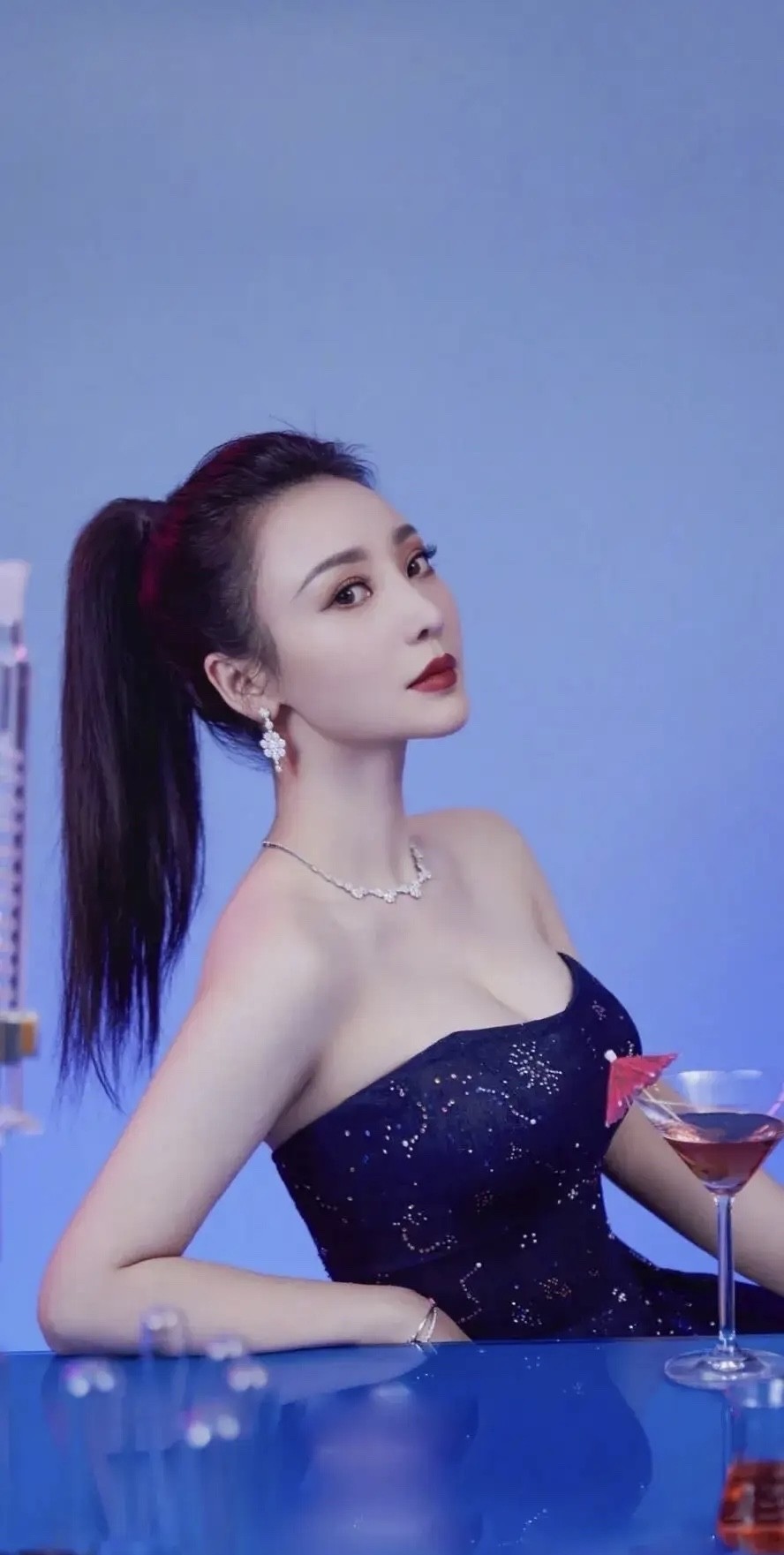 柳岩拍写真穿搭，高扎马尾妆容精致，气质妩媚好出众，身穿蓝色抹胸连衣裙，曼妙的身材