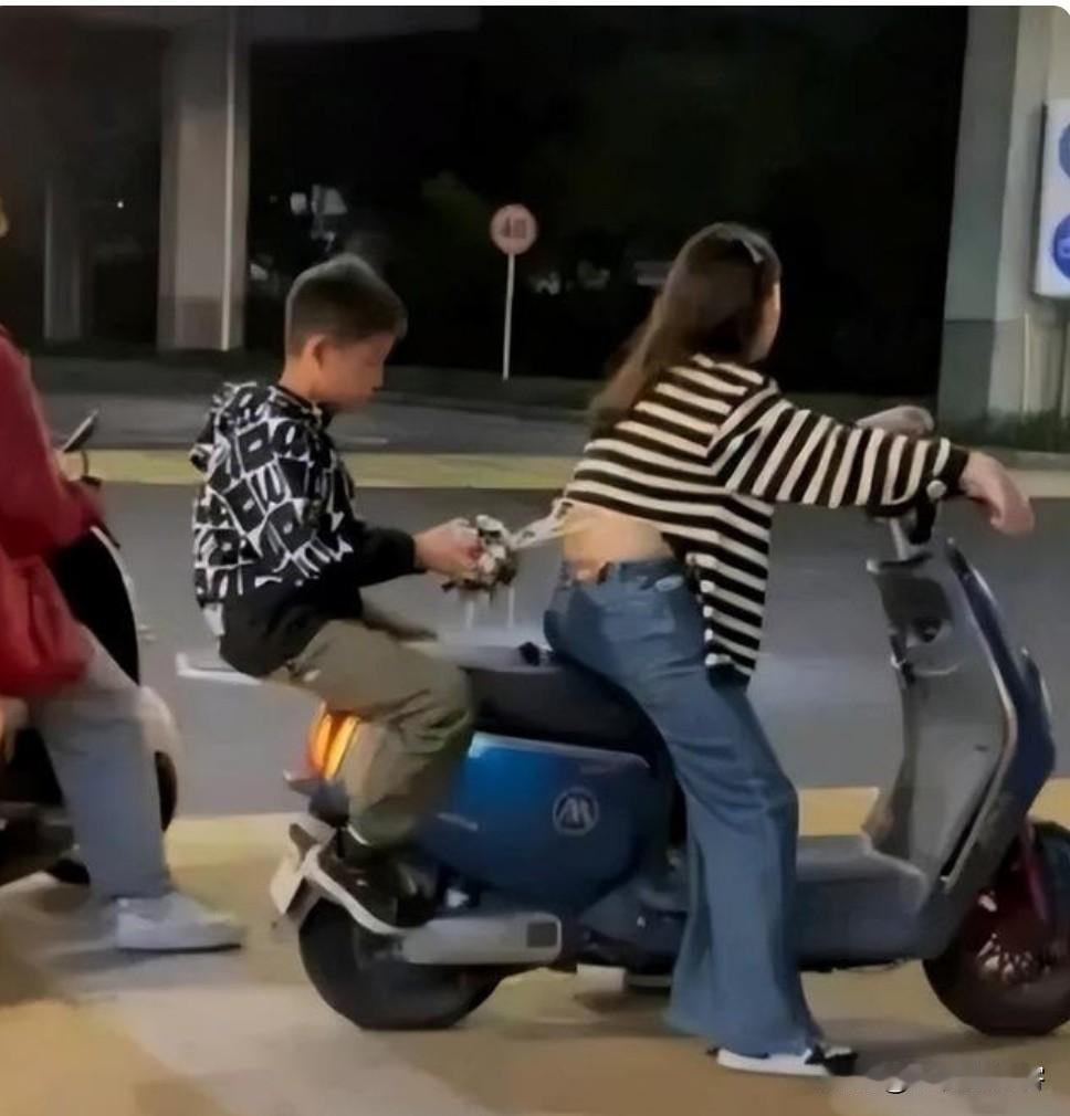 路上骑车，你永远猜不到后座的小不点能整出啥“惊喜大作”。路口等红灯，一位妈妈