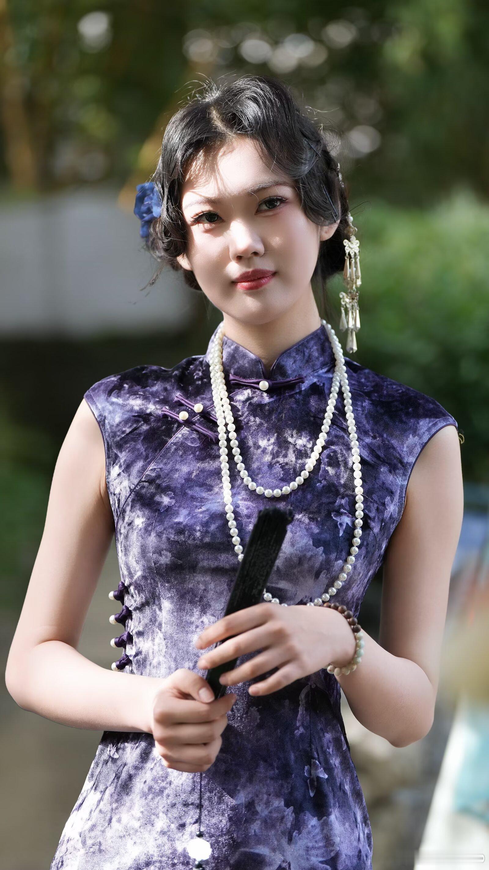 一袭晕染紫旗袍，缀着珍珠与盘扣，在江南的光影里，复刻旧时光里的温婉与风情。模特漂