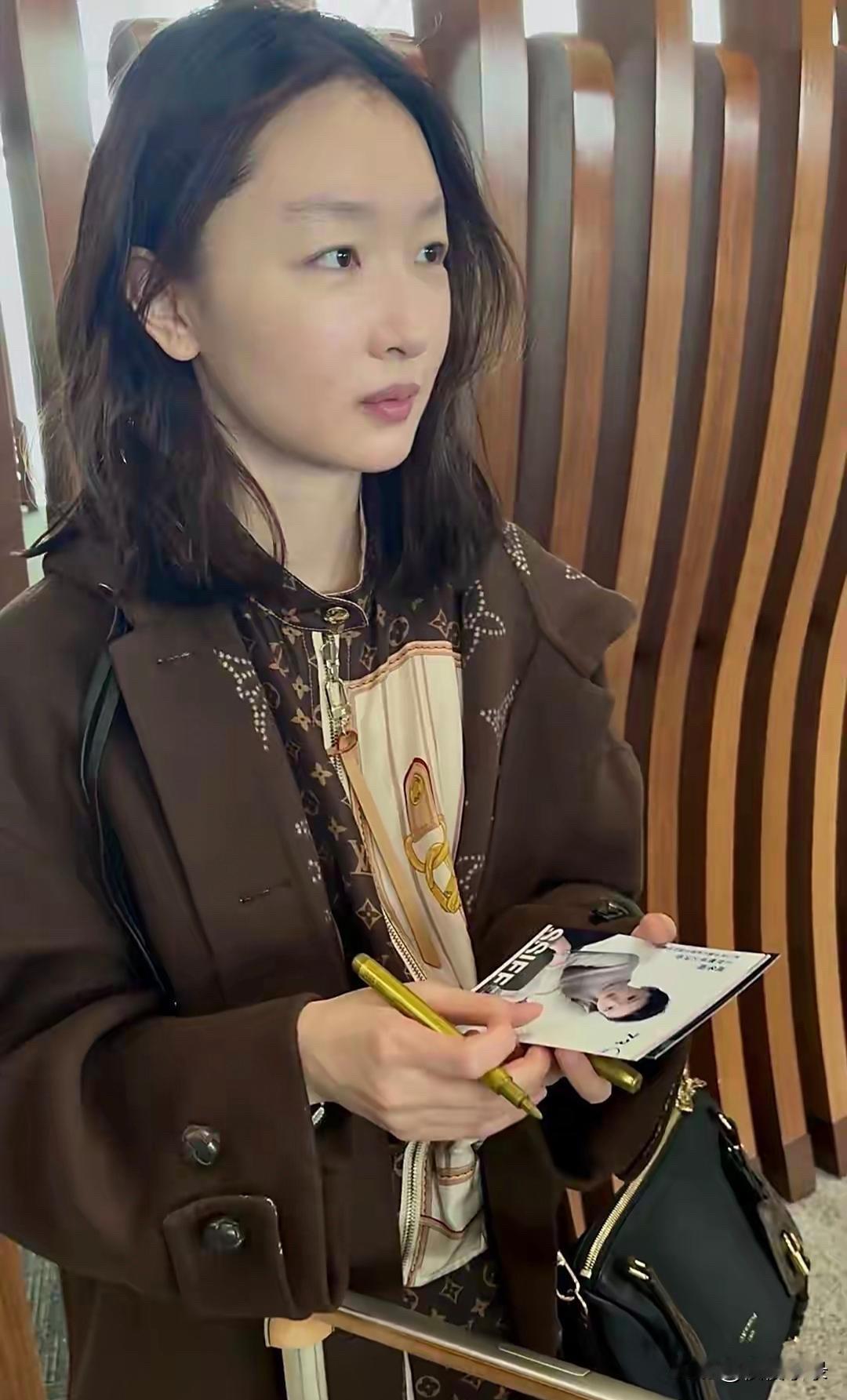周冬雨北京出发圣塞机场图，穿棕色大衣搭连衣裙，素颜皮肤仍细腻！[赞][赞][给力